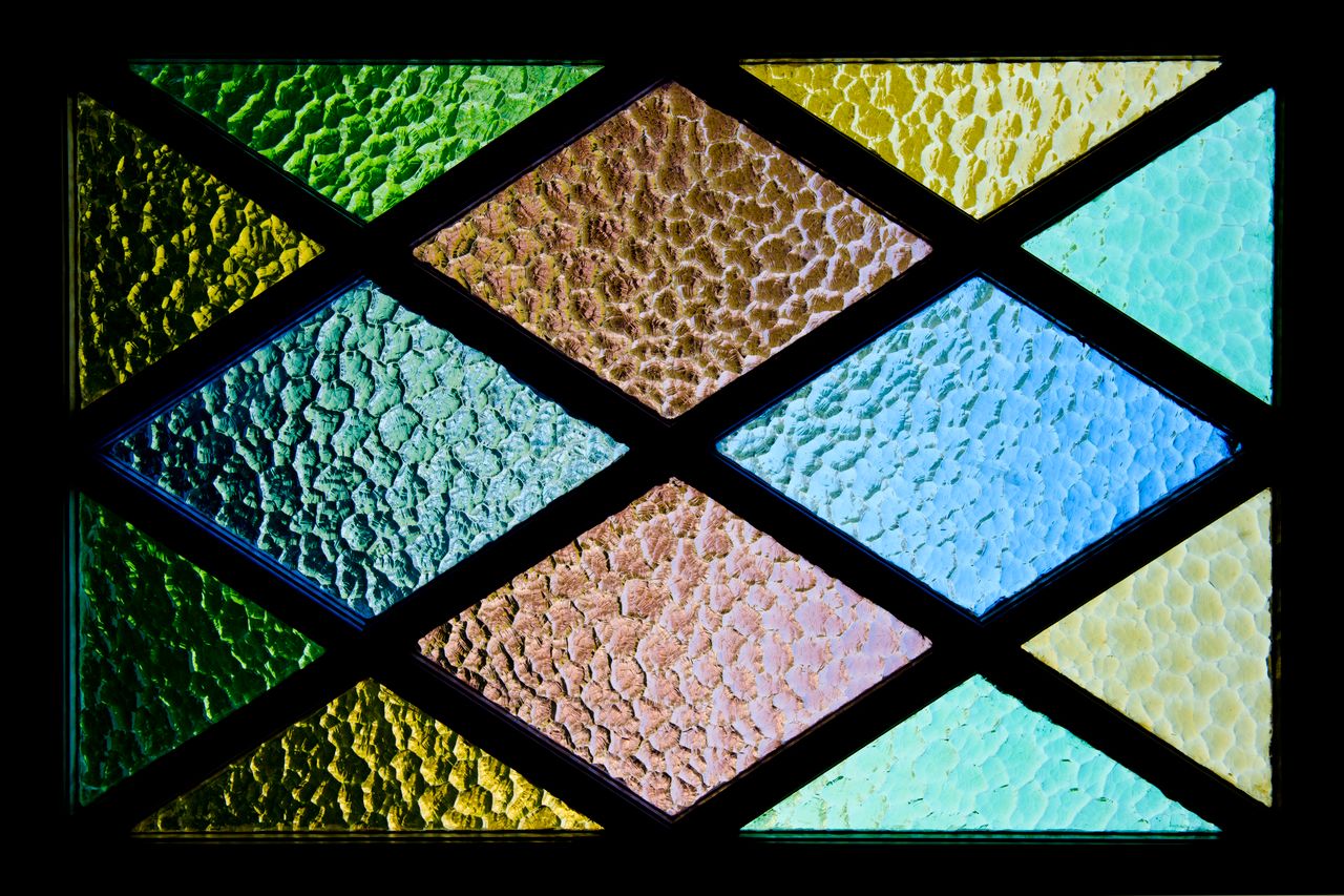 Services-01 Vibrant stained glass featuring textured geometric patterns and colorful hues.